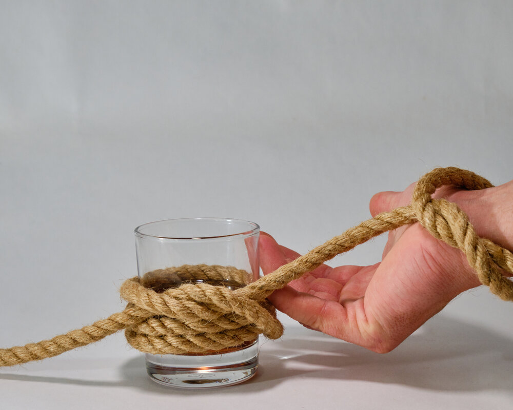 рюмка водки связанная с рукой веревкой