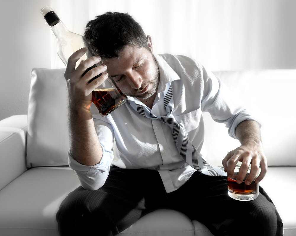 страдающий от алкоголизма мужчина с бутылкой